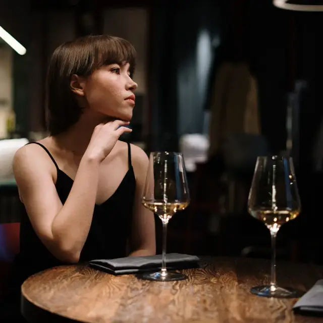 Evening with two glasses of white wine on a dark wood table at MERO 18