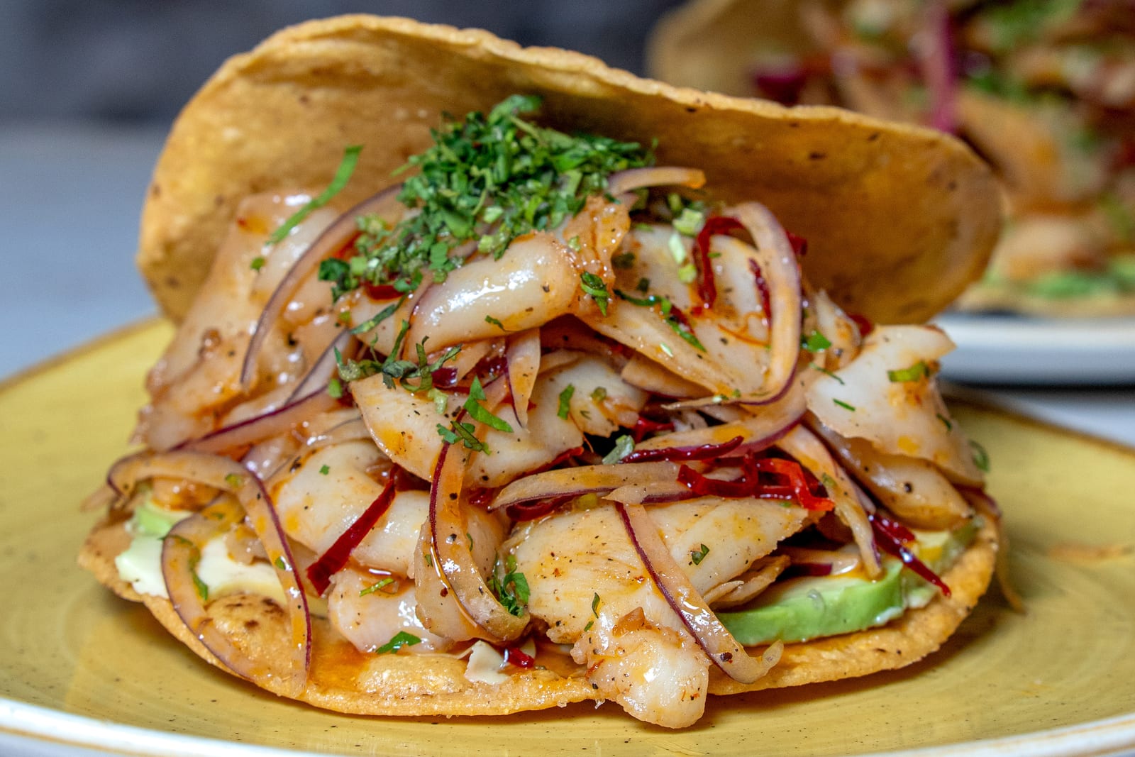 Tostada de mariscos en Cancún: ceviche de pescado estilo aguachile rojo con cebolla morada, chile seco, cilantro y aguacate en la barra de MERO 18