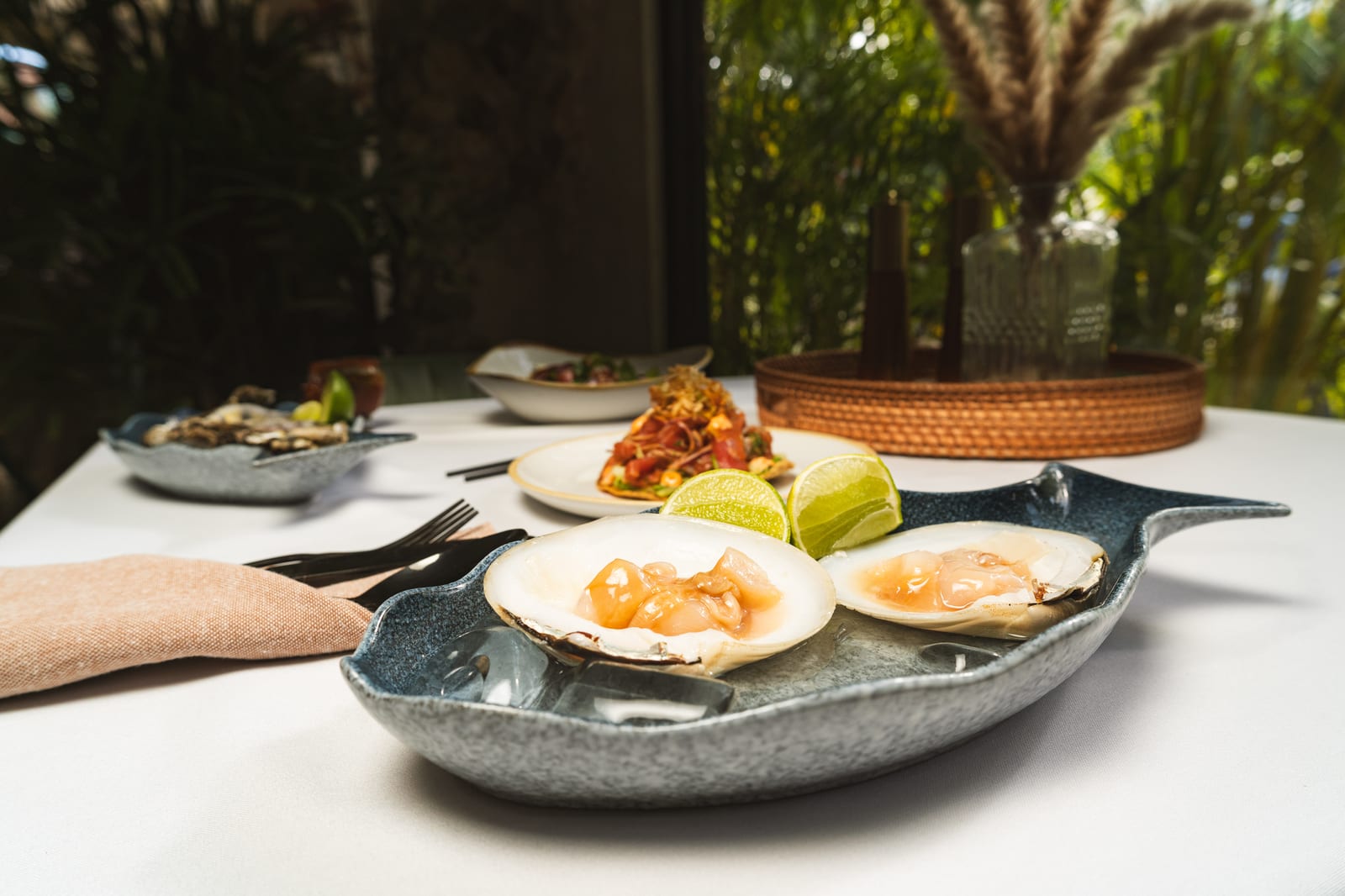 Fresh clams, tuna tostadas and oysters spread across a table at MERO 18