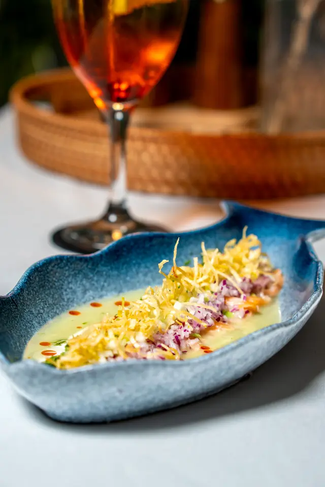 Shrimp ceviche with crispy leek on a fish-shaped plate
