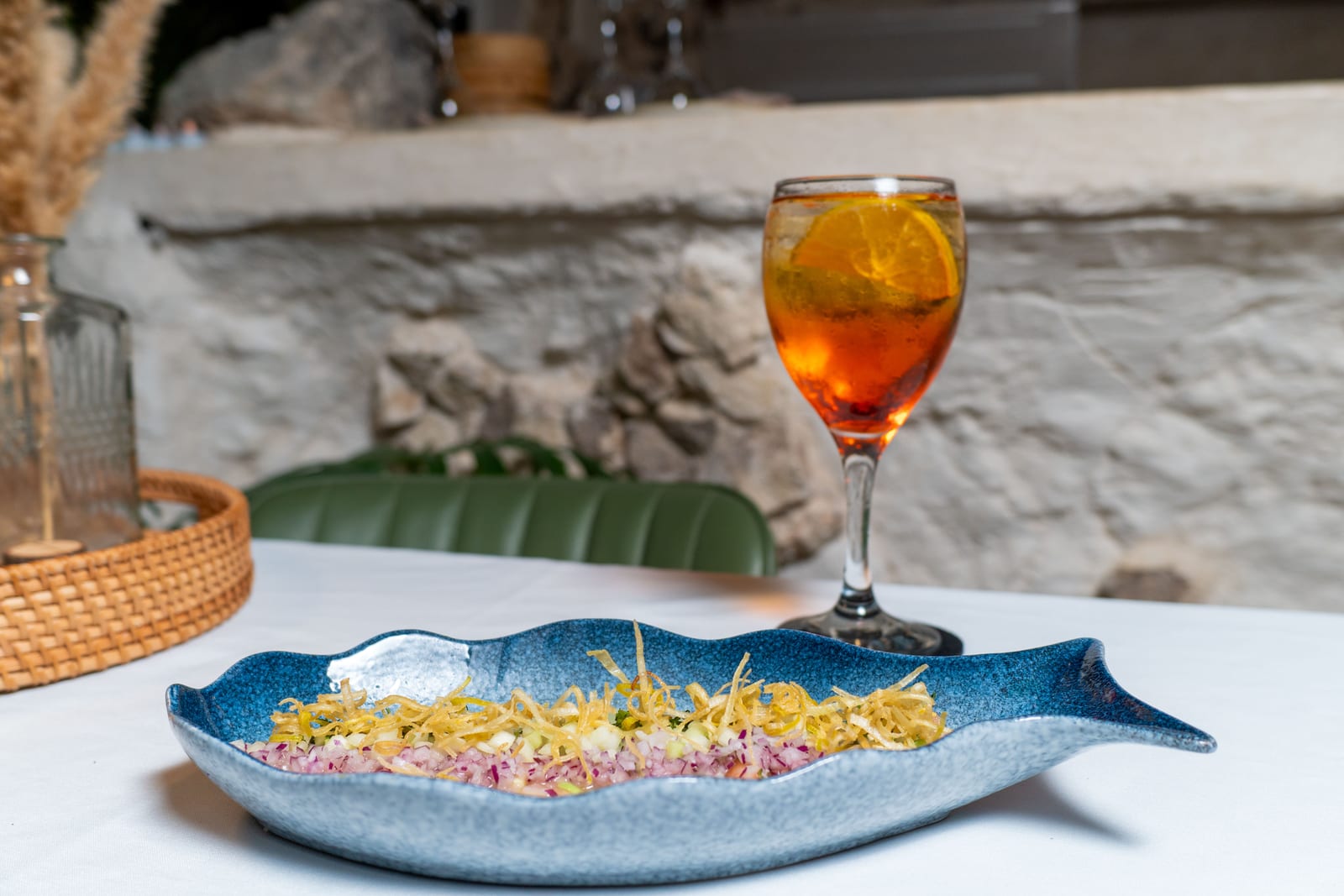 Plato de ceviche con poro frito junto a un Aperol Spritz en la barra de piedra de MERO 18, sea bar del Centro de Cancún