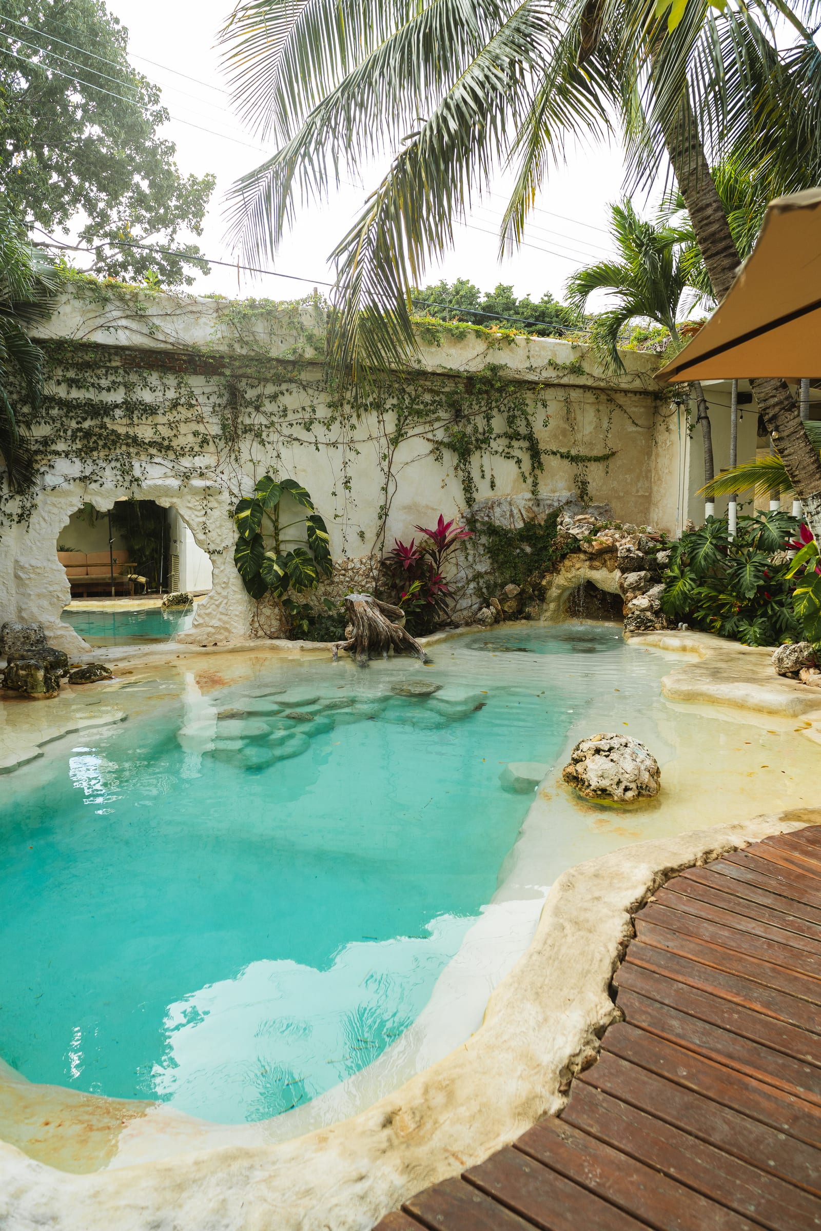 Cenote-style pool with a rock waterfall and tropical plants at a hotel with pool and spa in downtown Cancún