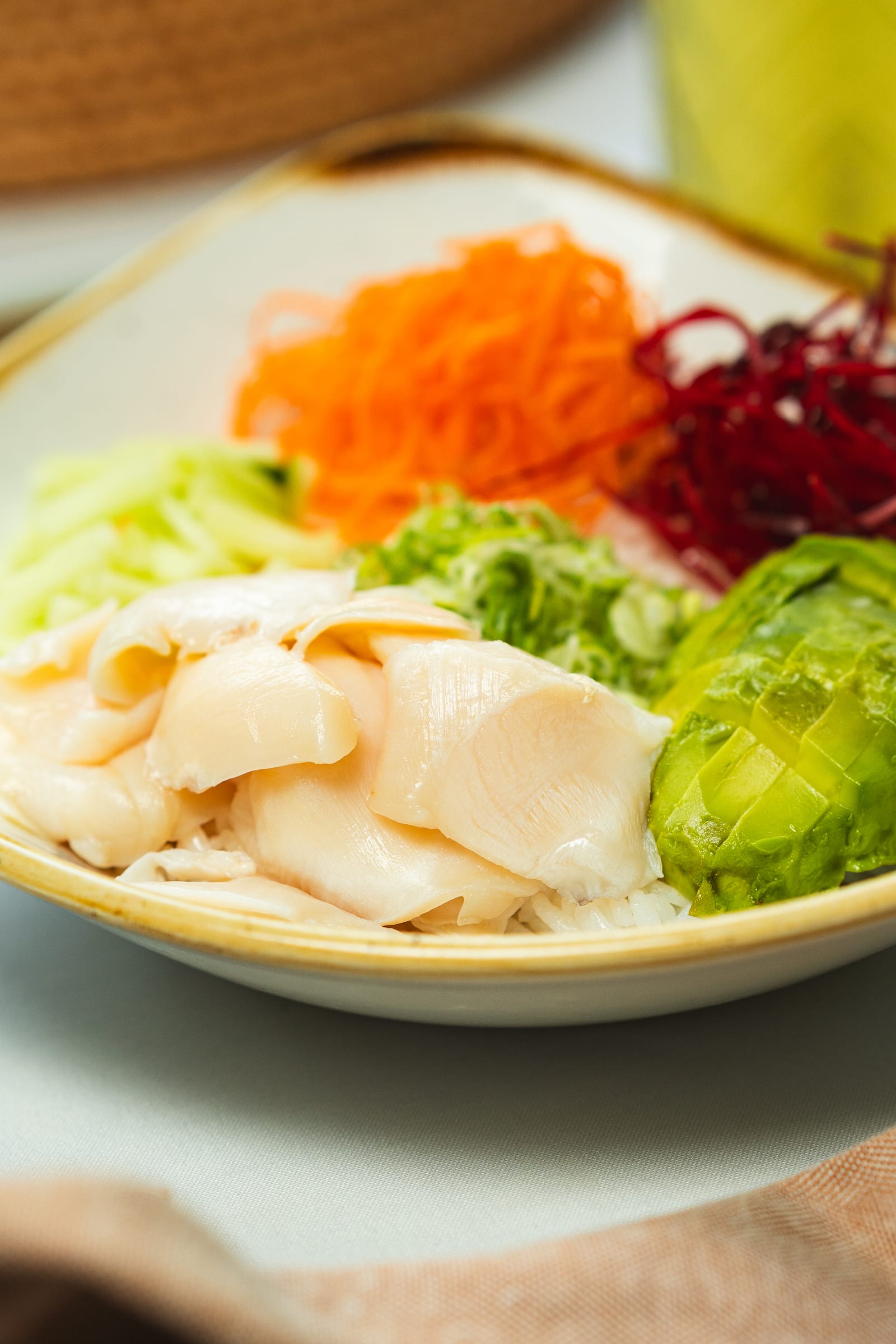 Pesca del día en láminas: pescado blanco fresco con aguacate, pepino, zanahoria y betabel en plato de la barra fría de MERO 18