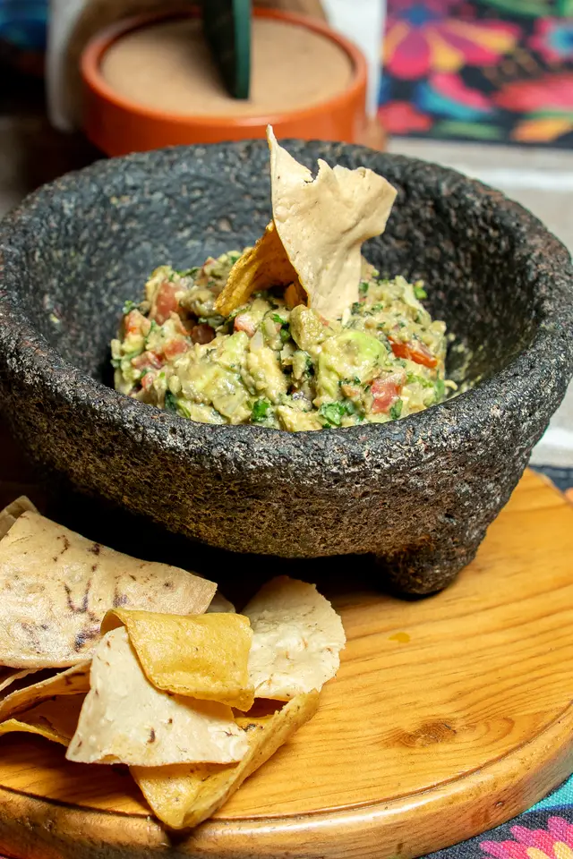 Guacamole in a molcajete with tortilla chips