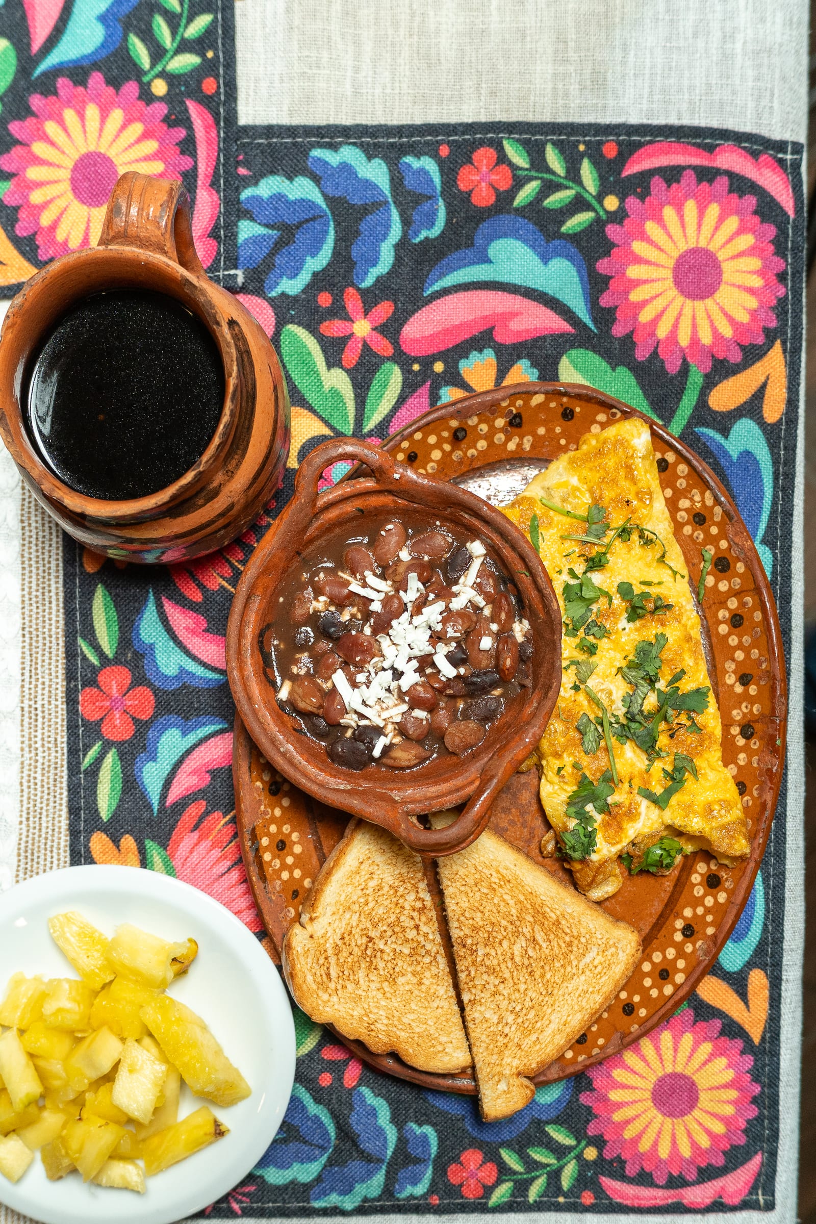 Desayuno en MERO 18: omelette con cilantro, frijoles con queso en cazuela de barro, pan tostado y café