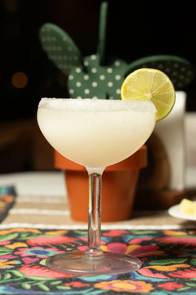 Frosted margarita in a coupe glass with a lime wheel