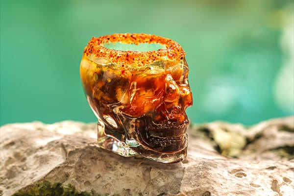 Seafood shot served in a glass skull with a chile-salt rim by the pool